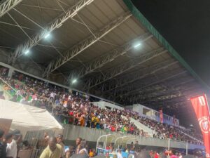 Fans at Molyko Omnisport stadium watch musicians perform 